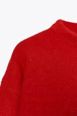 Jersey rojo de punto con cuello redondo y manga larga. Bajo con aberturas laterales.