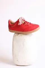 Zapatillas bajas marrones de gamuza con cordones y detalle de aplique de fresa en los cordones.