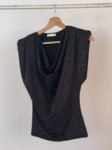Blusa color borgoña con cuello drapeado, mangas cortas con hombreras y pequeños lunares plateados.