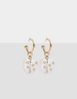 Aros dorados tipo argolla con dije de corazón transparente con incrustaciones de estrellas doradas.