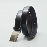 Cinturón de cuero sintético negro con hebilla automática plateada con diseño texturizado.