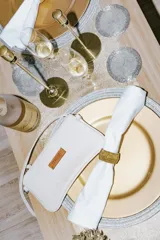 Mini cartera de cuero color crudo con correa larga extraíble y bolsillo interno con cierre.