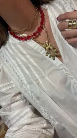 Collar doble dorado con cadena de eslabones rectangulares y dije abstracto.