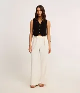 Chaleco negro de crepé con escote en V y abotonadura dorada. Corte slim y sin mangas.