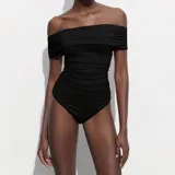 Body negro con escote off-shoulder y mangas cortas.