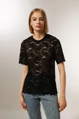 Top negro de encaje con mangas cortas, cuello redondo y corte holgado.