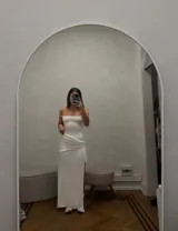 Vestido largo blanco elastizado con sobre falda asimétrica y estilo corset en la espalda.