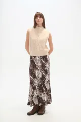 Chaleco sin mangas color beige, con cuello alto y tejido de ochos.