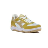 Championes deportivos Diadora modelo B.560 Vintage, de caña baja, con combinación de colores amarillo mostaza, blanco y beige. Presentan paneles de gamuza y cuero sintético, puntera perforada y suela de goma color caramelo.