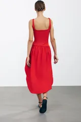 Vestido midi rojo de escote cuadrado y tirantes anchos. Detalle de bajo redondeado en tejido combinado a tono.