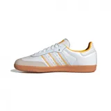 Championes Adidas Samba OG de cuero blanco con detalles en naranja y suela de goma marrón.