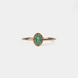 Anillo de oro amarillo 18k con esmeralda ovalada y pequeños brillantes alrededor.