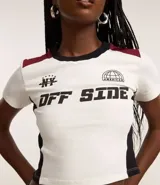 Blusa corta de algodón color blanco con mangas cortas, cuello redondo y bloques de colores en contraste en los laterales y en los hombros. Tiene lettering "NY - American Off Side" estampado en el pecho.