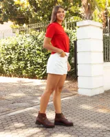 Botinetas de cuero color marrón con suela track negra. Presentan un cierre frontal con detalle en color rojo, dos correas con hebillas metálicas ajustables y puntera redondeada.