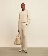 Buzo deportivo femenino confeccionado en microfibra color beige, con cuello redondo, mangas raglán largas y recortes.