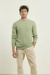 Sweater verde de punto fino con estructura tipo punto abeja, cuello redondo, manga larga y terminaciones elásticas en canalé.