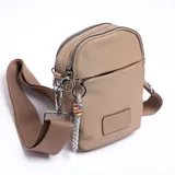 Bandolera porta celular color beige con correa larga regulable y cierre superior.