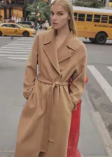 Abrigo largo color camel, con cuello con solapa, corte oversize y cinturón desmontable.
