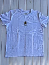 Remera blanca con estampado de palmeras y sol en la espalda.