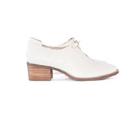 Zapato de cuero texturizado color blanco hueso, con punta cuadrada, detalle de hebilla dorada y taco de madera.