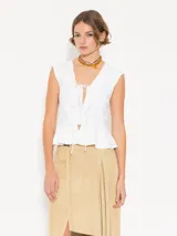 Top blanco de lycra doble, con mangas japonesas y escote en V con lazos de poplin. Tiene doble volado caracol en el ruedo.