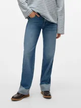 Jeans de mezclilla azul medio, tiro medio, corte recto y largo extra, con puños doblados y deshilachados en el borde.