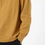 Camisa color mostaza de manga larga con cuello mao y cierre parcial con botones.