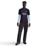 Camiseta de fútbol Nike del Paris Saint-Germain, modelo Stadium, temporada 2025/26, para hombre. Diseño azul con franja vertical central con patrón de cruces rojas y blancas. Incluye logo de Nike, escudo del club y sponsor Qatar Airways en el frente.