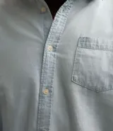 Camisa de jean celeste para hombre, de manga larga, con cuello solapa, abotonado delantero y bolsillo en el pecho.