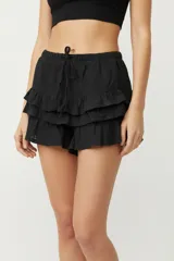 Minifalda negra con cintura elastizada y tres volados superpuestos.