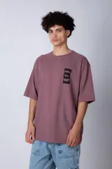 Remera verde militar de corte oversize con estampado negro en el frente.