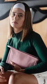 Neceser azul de neopreno con cierre superior y bolsillo interno de rejilla.