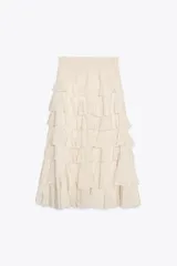 Falda midi color crudo confeccionada en tejido de viscosa, con cintura elástica y volantes en capas.