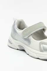 Zapatilla negra con tira ajustable y velcro.