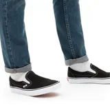 Zapatillas Vans Classic Slip-On negras con suela blanca.