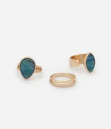 Set de tres anillos dorados con apliques de piedra marmolada azul.