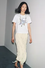 Camiseta blanca de algodón con cuello redondo y mangas cortas. Estampado frontal con la frase "Paris, Mon doux rêve!" en azul marino.