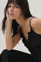 Top negro de lurex con tirantes finos regulables, volados en el frente y lazos en la espalda.