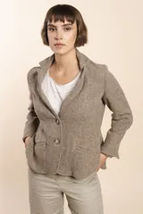 Chaqueta color crema de corte recto con cuello, solapa y bolsillos ojal. Forro solo en las mangas y terminaciones envivadas. Esquinas redondeadas y mangas con corte en puño que permiten transformarla en manga 3/4. Más larga en la espalda que en la delantera. Abrochadura con dos botones.