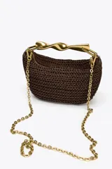 Bolso mini trenzado color marrón con asa de mano dorada metálica y doble asa bandolera ajustable y extraíble. Tiene forro, bolsillo interior y cierre mediante cremallera.