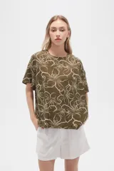 Blusa verde militar con estampado de flores blancas, de viscosa, corte holgado, cuello redondo y mangas cortas.