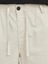 Short chino color beige de lino y algodón, con corte relajado, tiro semi caído, cintura con cordón ajustable, bolsillos delanteros y traseros.