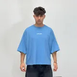 Remera verde militar con estampado amarillo en la espalda que incluye texto y logo de la marca. Corte boxy fit.