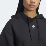 Canguro Adidas Essentials negro de corte holgado, con capucha ajustable con cordón, bolsillo tipo canguro, puños y dobladillo acanalados y logo pequeño bordado en blanco.