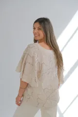 Blusa beige con estampado floral en tonos grises, escote en V y mangas cortas.