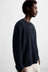 Jersey azul marino de punto, con cuello redondo y manga larga. Tejido en hilatura con mezcla de seda y lino.