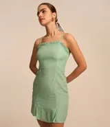 Vestido corto color verde agua, con breteles finos, escote recto con volados y falda con volado en el ruedo.