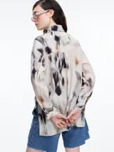 Camisa de manga larga confeccionada en viscosa crinkled con estampa de manchas. De silueta amplia y fluida, con bolsillos frontales grandes, tajos laterales y largo extendido en la espalda.
