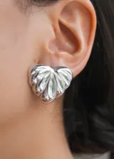 Par de aros plateados con forma de corazón con textura acanalada.
