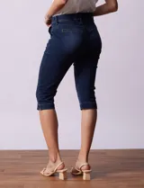 Pantalón capri blanco de algodón elastizado. Pretina con pasadores, botón y cierre. Delantera con bolsillos. Trasera con bolsillos simulados.